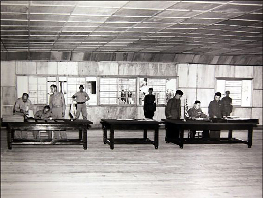 板門店で停戦協定に調印する国連軍代表(左)と中国・北朝鮮代表(右)。